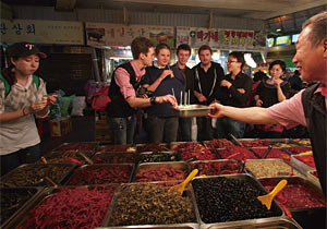 온고푸드의 ‘도보음식체험’ 프로그램에 참가한 외국 관광객들이 재래시장에서 음식을 먹고 있다.