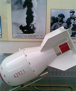 1964년 10월 16일 중국 신장위구르자치구 뤄부포에서 핵실험에 성공한 중국의 첫 번째 핵폭탄 실제 크기 모형. 뒤에 있는 사진은 핵실험 성공 후 피어오른 버섯구름.