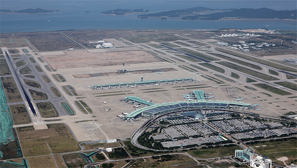 인천공항 전경. 공항철도와 KTX는 제1터미널(사진 아래 건물)을 지나 제3활주로(사진 왼쪽) 아래를 통과해 제2터미널(사진 위쪽 공터)로 들어가게 된다. ⓒphoto 인천공항