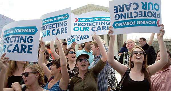 오바마 대통령의 건강보험법 개정을 지지하는 사람들이 워싱턴 대법원 앞에서 집회를 하고 있다. ⓒphoto 뉴시스
