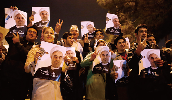 이란 수도 테헤란의 메라바드공항에서 지난해 11월 24일 시민들이 스위스 제네바에서 핵협상을 타결하고 귀국하는 대표단을 환영하기 위해 기다리고 있다. 이들은 하산 로하니 대통령의 사진을 들고 협상 타결을 축하했다. ⓒphoto AP