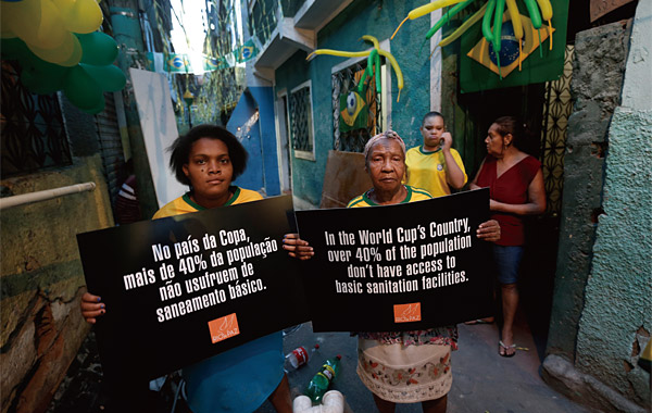지난 5월 21일 브라질 리우데자네이루 슬럼가에서 월드컵 개최를 반대하는 시민이 “40%가 넘는 브라질 국민이 기본적인 위생시설도 제공받지 못한다”는 글이 적힌 팻말을 들고 있다. ⓒphoto AP
