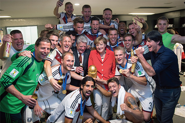 지난 7월 13일 브라질 리우데자네이루에서 열린 월드컵 결승전에서 우승한 독일 국가대표팀 선수들이 로커룸에서 메르켈 총리, 가우크 대통령과 우승 트로피를 들고 포즈를 취했다. ⓒphoto AP