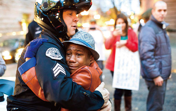 지난 11월 25일 포틀랜드시 교통경찰관 브렛 바넘이 시위 현장에서 소년 디본트 하트를 껴안고 있다. ⓒphoto AP·뉴시스