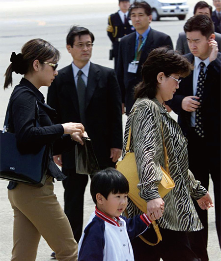 2001년 5월 일본 도쿄 나리타공항에서 얼굴이 공개된 김정남의 본부인 신정희(오른쪽)와 그 아들 김금솔(가운데), 왼쪽 선글라스 쓴 여성은 신정희의 친척으로 알려진 리경희이다.