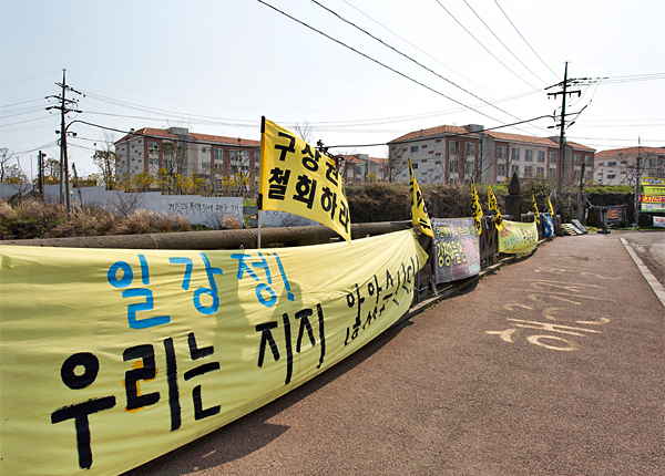 제주해군기지 영외 독신자숙소 옆 강정교에 걸려 있는 시위대의 현수막과 깃발.