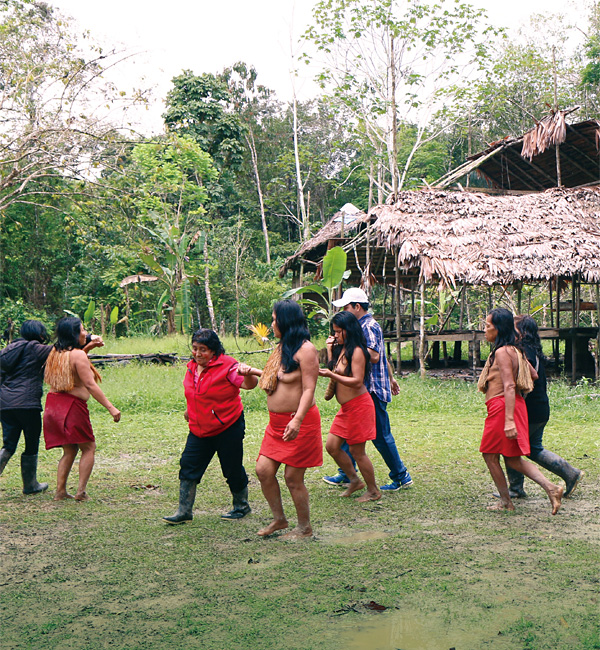 아마존강 정글 원주민 야구아족 마을에서 원주민과 관광객이 민속춤을 추고 있다.