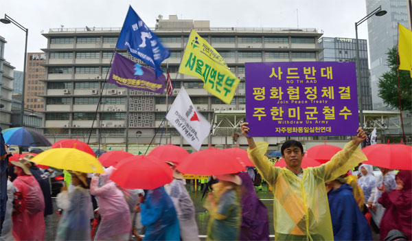 지난 8월 15일 서울광장에서 열린 8·15 범국민대회 참가자가 ‘평화협정체결’ ‘주한미군철수’가 적힌 팻말을 들고 있다. ⓒphoto 뉴시스