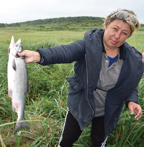 사할린 현지인 여성이 오호츠크해에서 갓 잡은 연어를 팔고 있다.