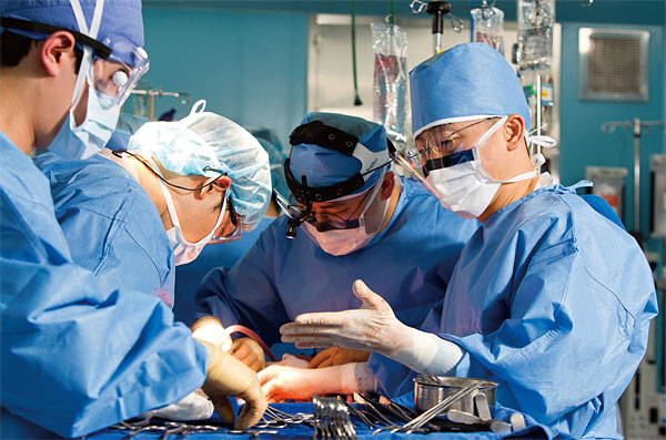 이국종 교수(오른쪽)가 권준식 교수(왼쪽에서 두 번째) 등 의료진과 함께 외상환자를 수술하고 있다.