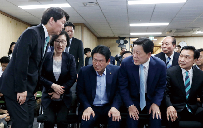 안철수 바른미래당 서울시장 후보(왼쪽)가 6월 13일 오후 서울 여의도 당사에서 6·13 지방선거 출구조사 결과 관련 입장을 밝히기 위해 들어서며 의원들과 인사를 나누고 있다. ⓒphoto 뉴시스