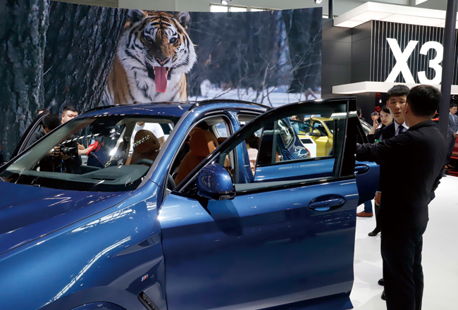 지난 4월 26일 중국 베이징에서 열린 ‘오토차이나 2018’에서 관객들이 BMW X3를 보고 있다. 이번 행사는 미·중 무역분쟁으로 빛이 바랬다. ⓒphoto AP
