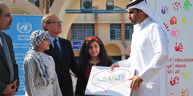 중동 최대 팔레스타인 난민캠프인 요르단 바카 난민촌의 학교에서 한 난민학생이 카타르개발기금 알 쿠와리 대표(오른쪽)에게 아랍어로 ‘감사해요 카타르’라고 쓴 스케치북을 건네고 있다. ⓒphoto 뉴시스