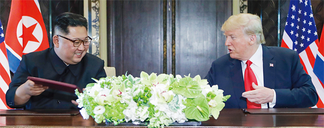 도널드 트럼프 미국 대통령과 김정은 북한 국무위원장이 지난 6월 12일 싱가포르 센토사섬 내 카펠라호텔에서 합의문에 서명한 후 웃고 있다. ⓒphoto 뉴시스