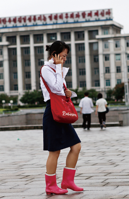 북한의 젊은 여성이 평양에서 휴대전화로 통화하면서 걸어가고 있다. ⓒphoto 위키피디아