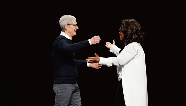 지난 3월 25일(현지시각) 미국 캘리포니아주 쿠퍼티노 스티브잡스극장에서 열린 애플 서비스 공개 행사에서 팀 쿡 애플 CEO와 방송인 오프라 윈프리가 포옹하고 있다. ⓒphoto AP·뉴시스