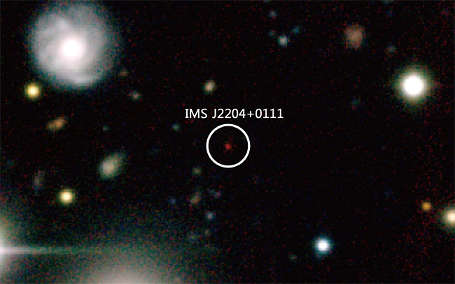 초기우주 퀘이사 IMS J2204+0111의 모습(그림 가운데 동그라미 안에 표시). 임명신 교수팀이 발견한, 지금으로부터 128억년 전에 있었던 퀘이사다. 오래된 천체는 망원경으로 관측하면 붉게 보인다. 우주의 팽창 때문에 멀리 있는 천체는 광속에 가까운 속도로 우리로부터 멀어지기 때문이다(적색이동). 128억년 전 우주의 크기는 현재보다 7분의 1 정도 작았다.