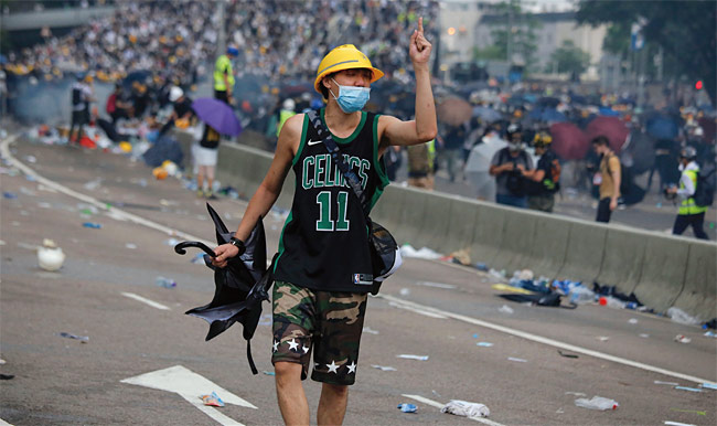 지난 6월 12일 한 홍콩 청년이 노란모자를 쓰고 우산을 들고 시위에 나서고 있다. ⓒphoto 뉴시스
