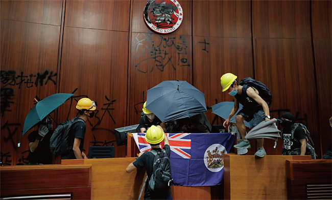 지난 7월 1일 밤, 홍콩 입법회 본회의장을 점거한 시위대가 단상에 영국령 홍콩기를 걸고 있다. ⓒphoto AP·뉴시스