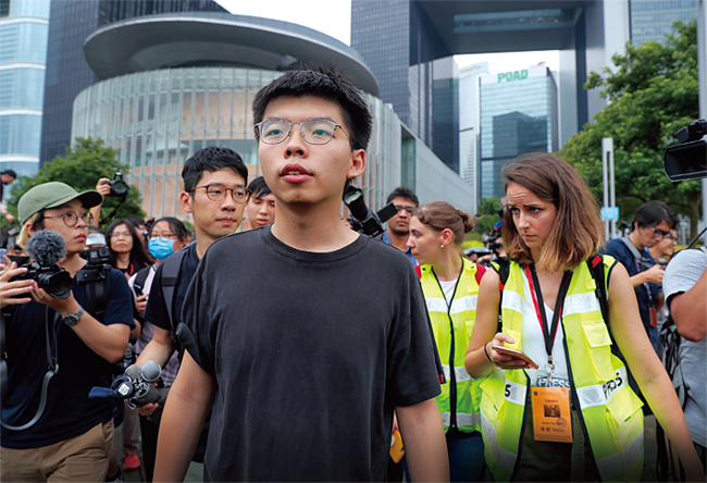 지난 6월 17일 교도소에서 갓 출소한 조슈아 웡이 홍콩 입법회 앞에서 기자회견을 마치고 이동하고 있다. ⓒphoto AP·뉴시스