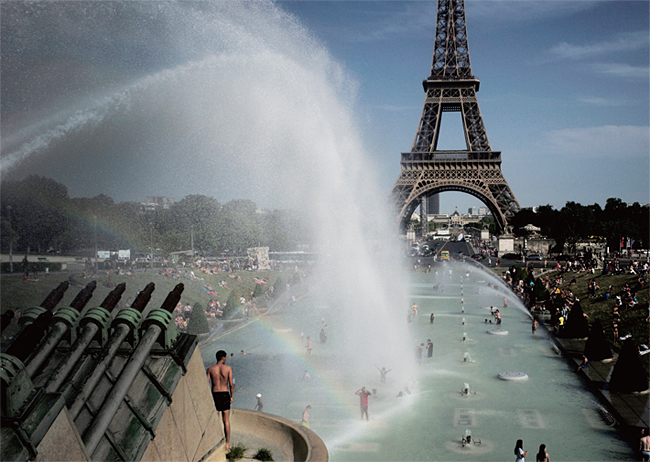 지난 6월 28일 프랑스 파리 에펠탑 근처의 모습. 기록적인 폭염 속에서 더위를 식히기 위해 물을 뿌리고 있고, 사람들은 벌거벗고 더위를 식히고 있다. ⓒphoto 뉴시스·AP