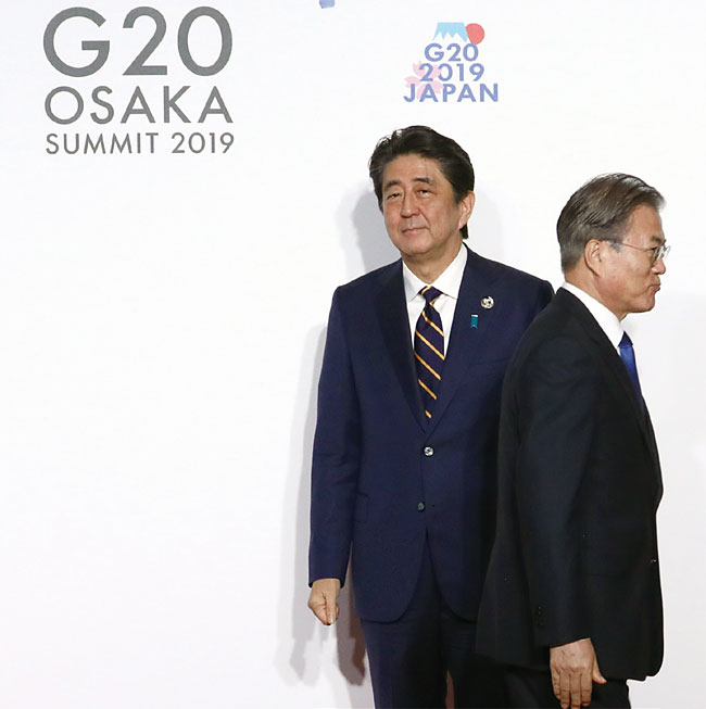 문재인 대통령이 지난 6월 28일 일본 오사카에서 열린 G20 정상회의 공식환영식에서 의장국인 일본 아베 신조 총리와 악수한 뒤 행사장으로 향하고 있다. ⓒphoto 뉴시스