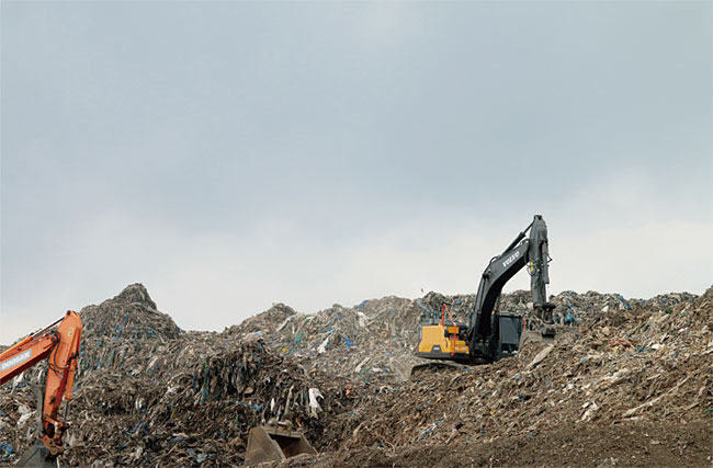 경북 의성군에 형성된 ‘쓰레기산’ 위에서 폐기물 처리업체가 포크레인을 동원해 쓰레기 선별 작업을 벌이고 있다. ⓒphoto 이성진 기자