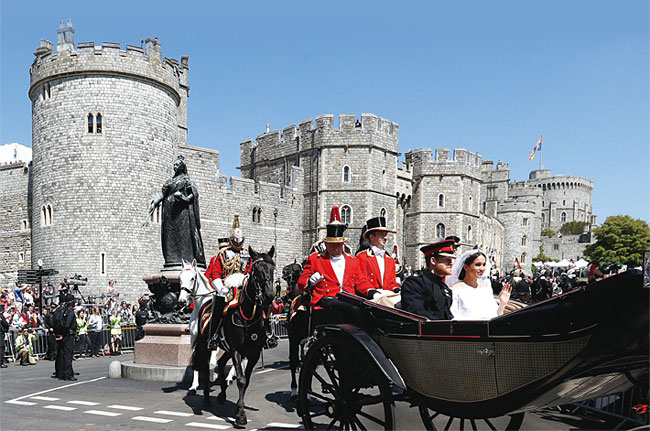 지난해 5월 19일 영국 해리 왕자와 메건 마클이 윈저성에서 열린 결혼식 후 마차를 타고 성을 떠나고 있다. ⓒphoto 뉴시스