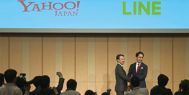 이데자와 다케시 라인 사장(왼쪽)과 가와베 겐타로 Z홀딩스 사장이 지난 11월 18일 경영 통합을 공식화하는 기자회견에서 서로 손을 맞잡고 있다. ⓒphoto ANN뉴스