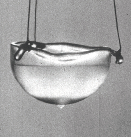 초유체 상태인 헬륨이 용기 밖으로 표면을 타고 흘러나온다. 용기 아래에 방울이 맺힌 게 보인다. ⓒphoto 위키피디아