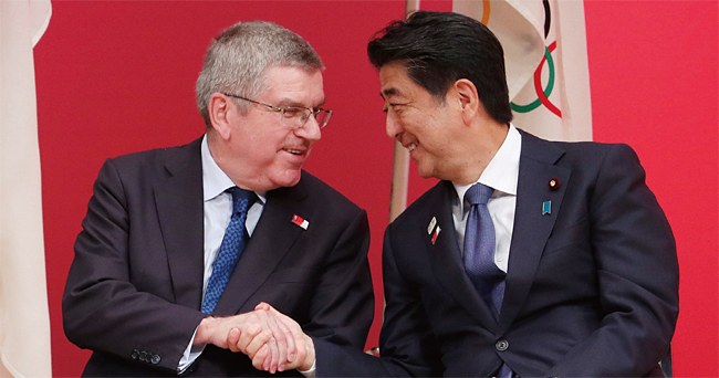 지난해 7월 24일 도쿄올림픽 준비 행사에서 토마스 바흐 IOC 위원장(왼쪽)과 악수를 나누는 아베 총리. ⓒphoto 뉴시스