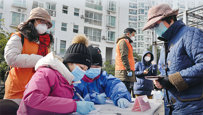 지난 2월 11일 중국 상하이의 한 아파트 주민위원회에서 마스크 예약 신청을 받고 있다. ⓒphoto 신화·뉴시스