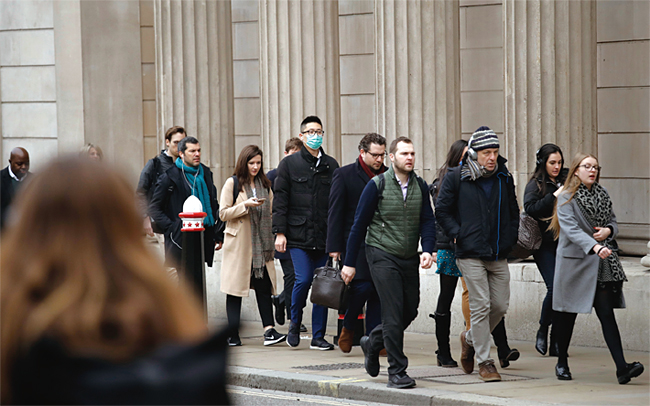 지난 3월 4일 런던 잉글랜드 은행 앞을 지나는 시민들. 동양인으로 보이는 한 남자만 마스크를 착용하고 있다. ⓒphoto 뉴시스
