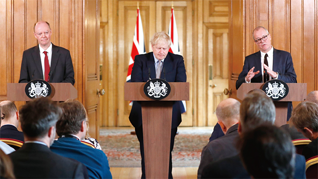 지난 3월 3일 보리스 존슨 영국 총리(가운데)가 수석의학사무관 크리스 위티(왼쪽), 수석과학고문 패트릭 발랜스와 함께 코로나19 사태 관련 기자회견을 하고 있다. ⓒphoto 뉴시스