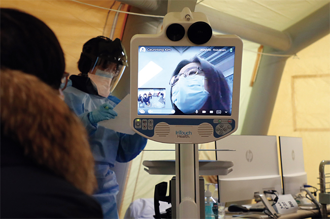 명지병원 의료진이 원격진료로봇을 활용해 코로나19 의심환자 진료를 시연하고 있다. ⓒphoto 남강호 조선일보 기자