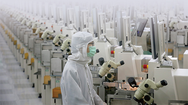 지난 2월 23일 중국 장시성 더싱시의 한 렌즈 공장에서 직원이 제품을 점검하고 있다. ⓒphoto 뉴시스
