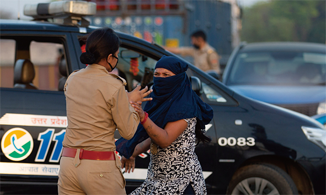 지난 4월 14일(현지시각) 인도 프라야그라즈에서 한 경찰관이 검문에 불응하고 차를 멈추지 않은 한 여성 운전자를 체포하고 있다. ⓒphoto 뉴시스