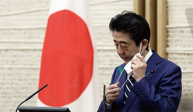 일본 아베 총리가 지난 4월 17일 기자회견장에서 마스크를 벗고 있다. ⓒphoto 뉴시스