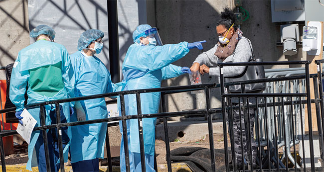 미국 뉴욕의 브루클린병원 선별진료소에서 의료진이 코로나19 검사를 받으러 온 한 여성을 안내하고 있다. ⓒphoto 뉴시스