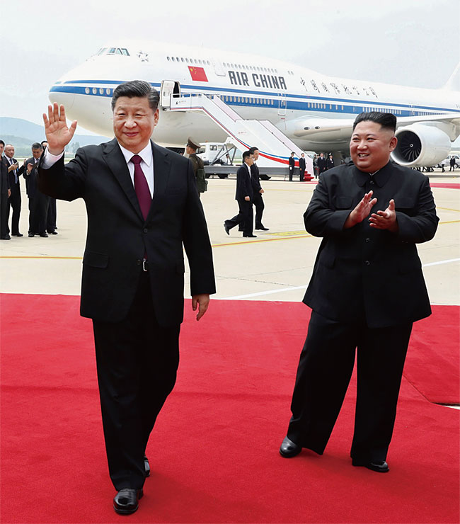 지난해 6월 북한을 국빈 방문한 시진핑 중국 국가주석(왼쪽)이 평양 순안공항에 도착해 김정은 북한 국무위원장의 영접을 받으며 환영인파에 인사하고 있다. ⓒphoto 뉴시스