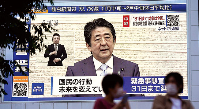 아베 총리가 지난 5월 4일 기자회견을 통해 코로나19로 인한 긴급사태를 5월 말까지 연장한다고 선언했다. 이날 아베 총리의 기자회견 장면이 도쿄 시내의 대형 모니터를 통해 중계되고 있다. ⓒphoto 뉴시스