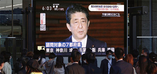 오사카 시민들이 코로나19 사태에 대한 아베 총리의 발표를 전광판으로 보고 있다. ⓒphoto 뉴시스