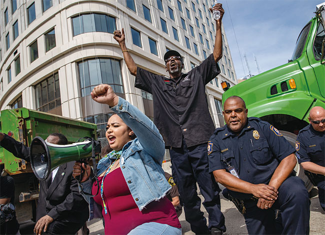 지난 6월 3일 미시간주 그랜드래피즈 경찰 간부들이 시위대와 함께 무릎을 꿇고 있다. ⓒphoto 뉴시스