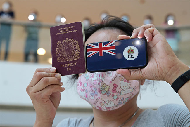 홍콩 국가보안법에 반대하는 시위대가 영국 국기와 여권을 들고 있다. 영국은 홍콩 반환 이전 영국 해외시민권을 갖고 있던 홍콩 시민 31만여명에게 영국 시민권을 제공하겠다고 밝혔다. ⓒphoto 뉴시스