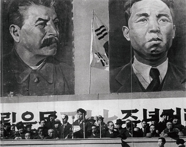1946년 3월 1일 북한 평양에서 열린 삼일절 기념식 때 자신과 소련공산당 서기장 스탈린의 대형 초상화 아래서 연설하는 김일성 당시 북조선임시인민위원장(가운데). 뒤에 걸린 태극기가 이색적이다. ⓒphoto 뉴시스