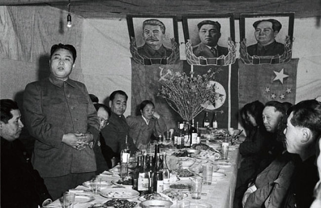 6·25전쟁 와중인 1951년 4월 북한을 찾은 중국인민위문단을 맞이하여 연회를 주재한 김일성 당시 조선인민군 총사령관. 뒤로 자신의 초상화와 함께 소련 스탈린(왼쪽), 중국 마오쩌둥(오른쪽)의 초상화와 국기가 걸려 있다. ⓒphoto 바이두