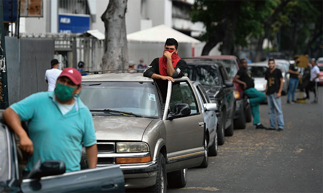 베네수엘라 카라카스 시민들이 자동차에 주유하기 위해 길게 줄을 서 있다. 베네수엘라는 세계적인 원유 생산국이지만 반기업적 정책으로 정유업을 비롯한 제조업이 와해됐다. ⓒphoto 뉴시스
