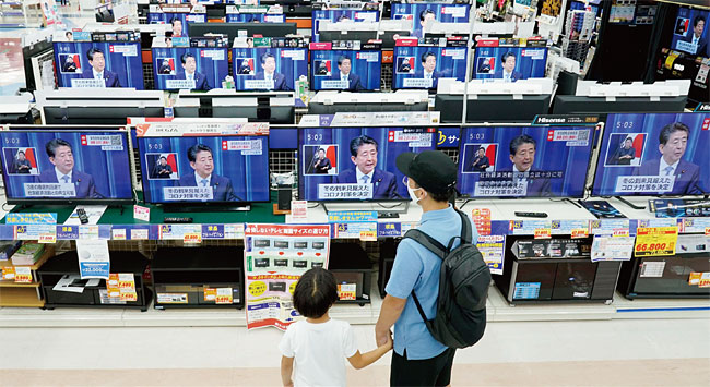 지난 8월 28일 오후 도쿄의 한 시민이 TV로 중계되는 아베 총리 사임 기자회견을 지켜보고 있다. ⓒphoto 뉴시스