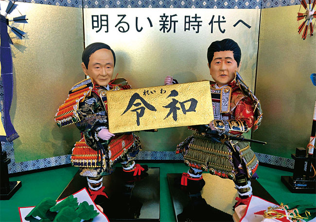 나루히토 일왕의 새 연호 ‘레이와’를 들고 있는 스가 장관(왼쪽)과 아베 총리를 묘사한 전통 인형. ⓒphoto 뉴시스
