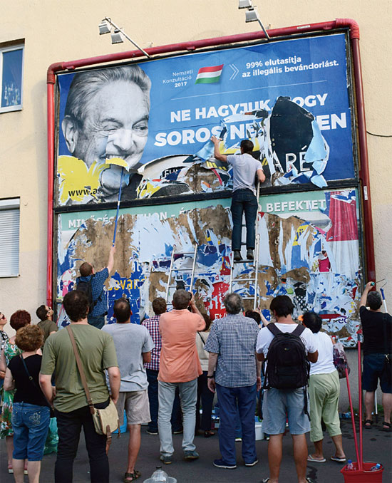 헝가리 친정부 시위대들이 조지 소로스 선전 간판을 뜯어내고 있다. ⓒphoto 뉴시스